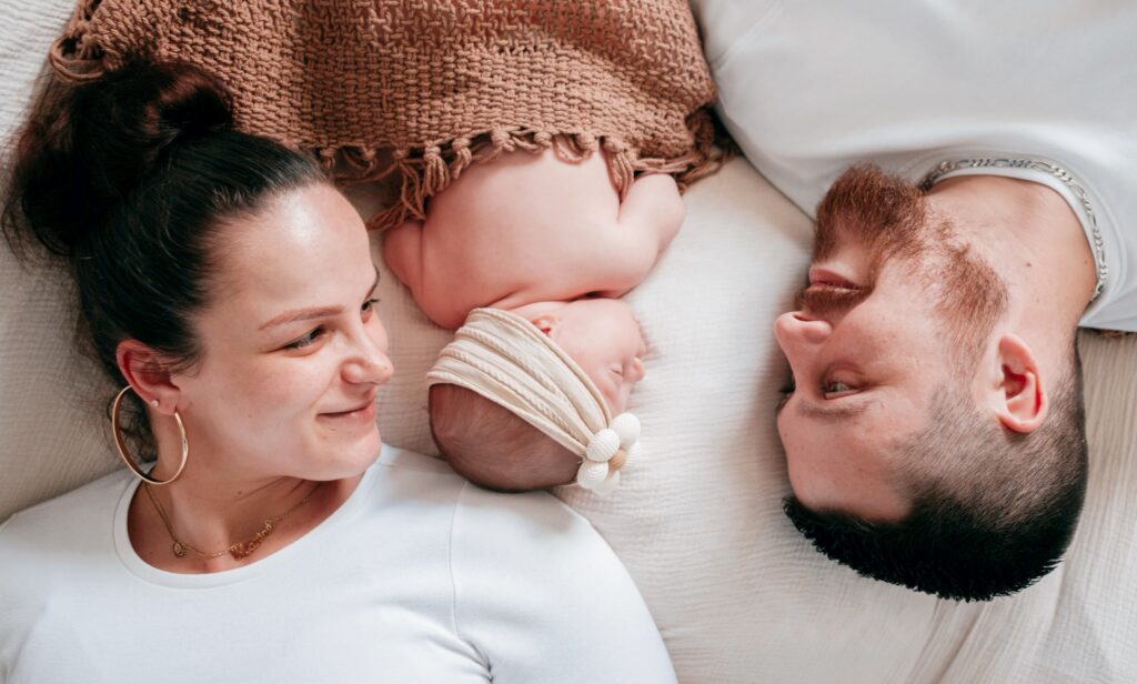 Bébé posé alongée entre papa et maman
